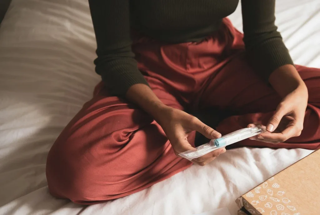 Person holding a microbiome test strip on a bed