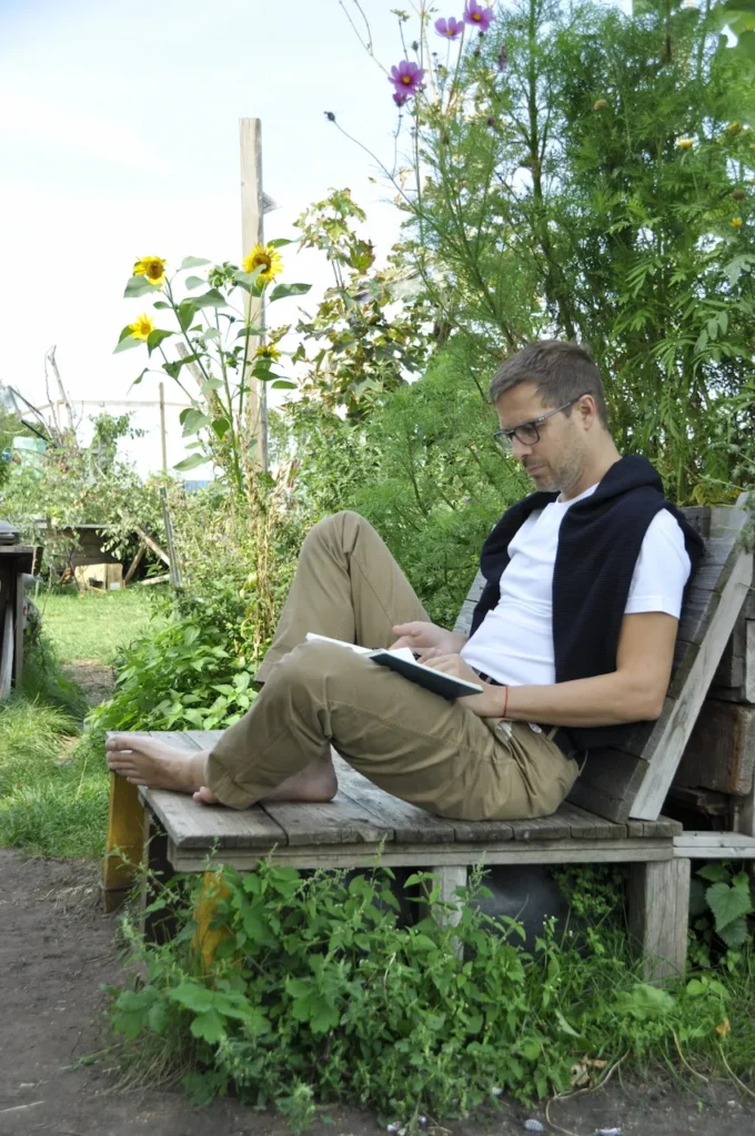 Bastian Hölscher reading in a garden